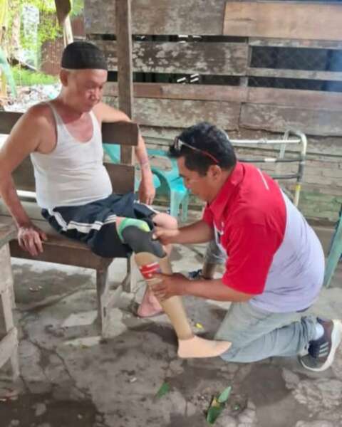 Mengenakan seragam JNE dan kaki palsu yang menemaninya bertugas, Bang Ramon kini membalas kehidupan dengan membantu orang lain berjalan kembali (Pewarta.co/dok ist)